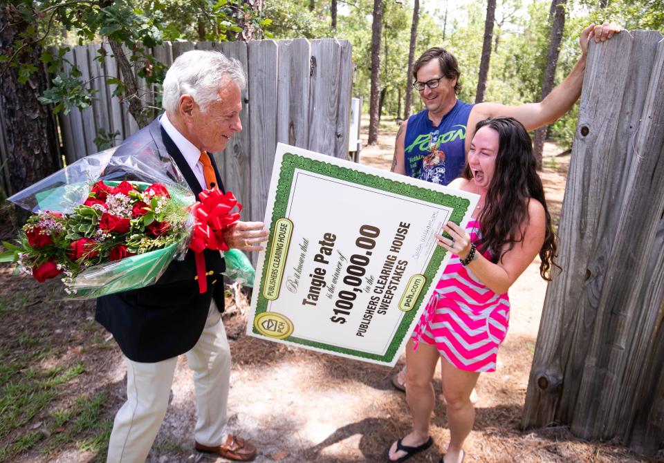 Publishers Clearing House Prize Patrol personality Dave Sayer, left, surprised Tangie Pate, right, and her husband, Mike Davis, center, Tuesday afternoon at their home near Dunnellon with a $100,000 check.