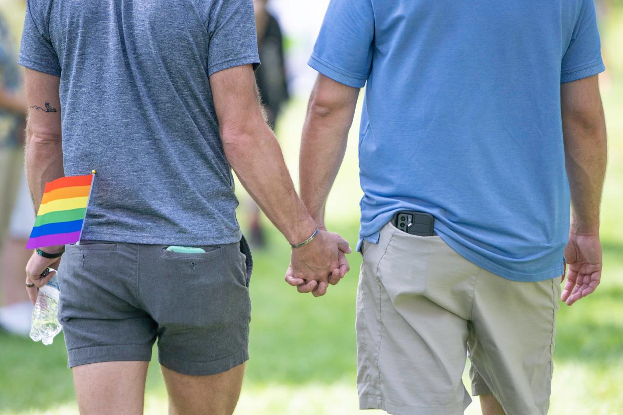 A couple walk hand-in-hand through Mineral Palace Park during Pueblo’s Pride festival on Sunday August 15, 2021.