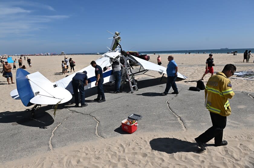 Huntington Beach, California July 22, 2022-Officials inspect the damage from a plane that crashed into the water in Huntington Beach Friday. (Wally Skalij/Los Angeles Times)