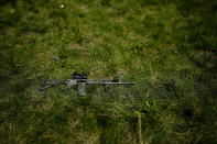 A rifle is seen on the grass as civilian militia men train at a shooting range in outskirts Kyiv, Ukraine, Tuesday, June 7, 2022. (AP Photo/Natacha Pisarenko)