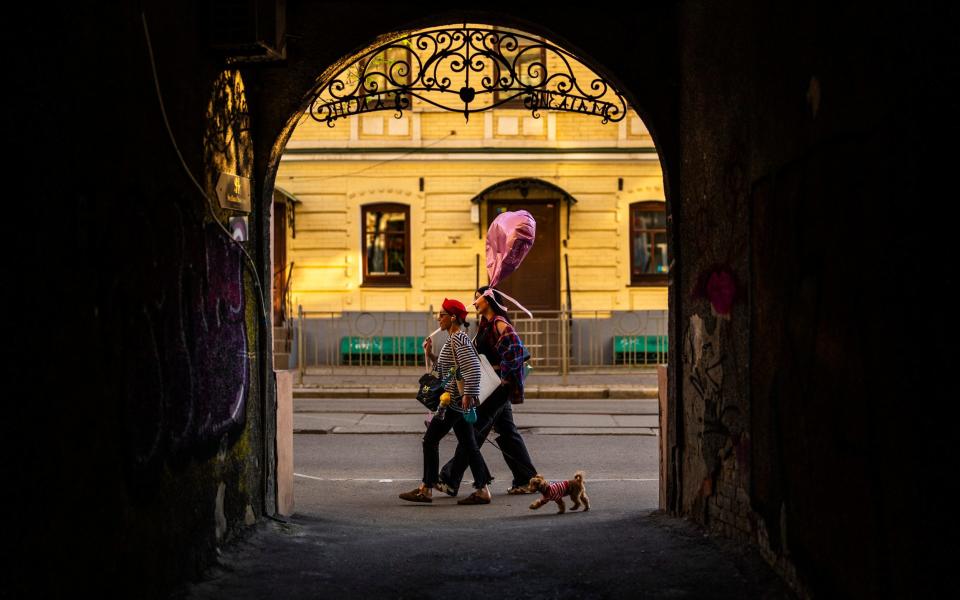 Two women walk along a street in downtown Kyiv
