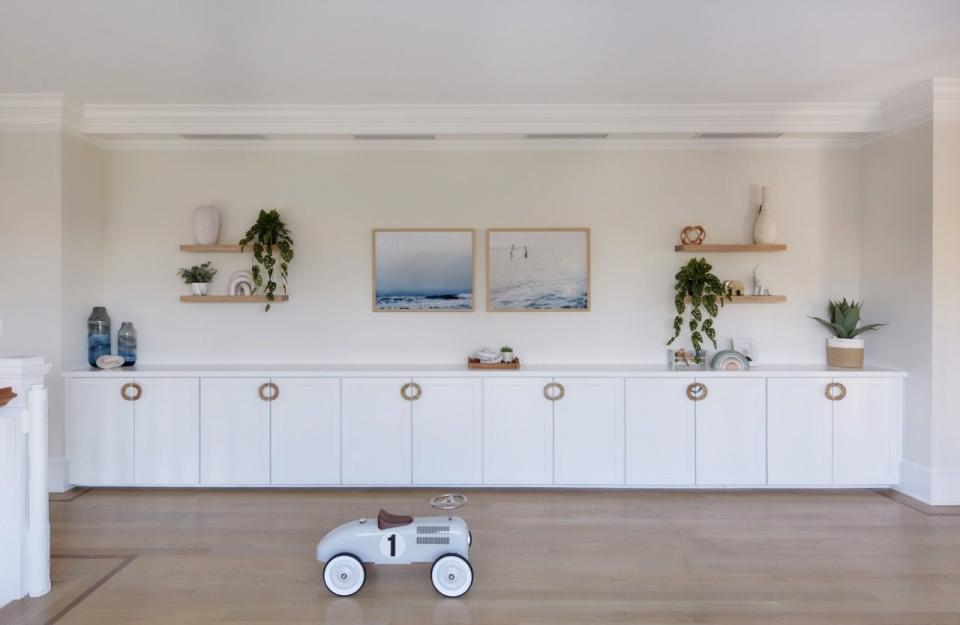 a room with white cabinets and a toy car in it