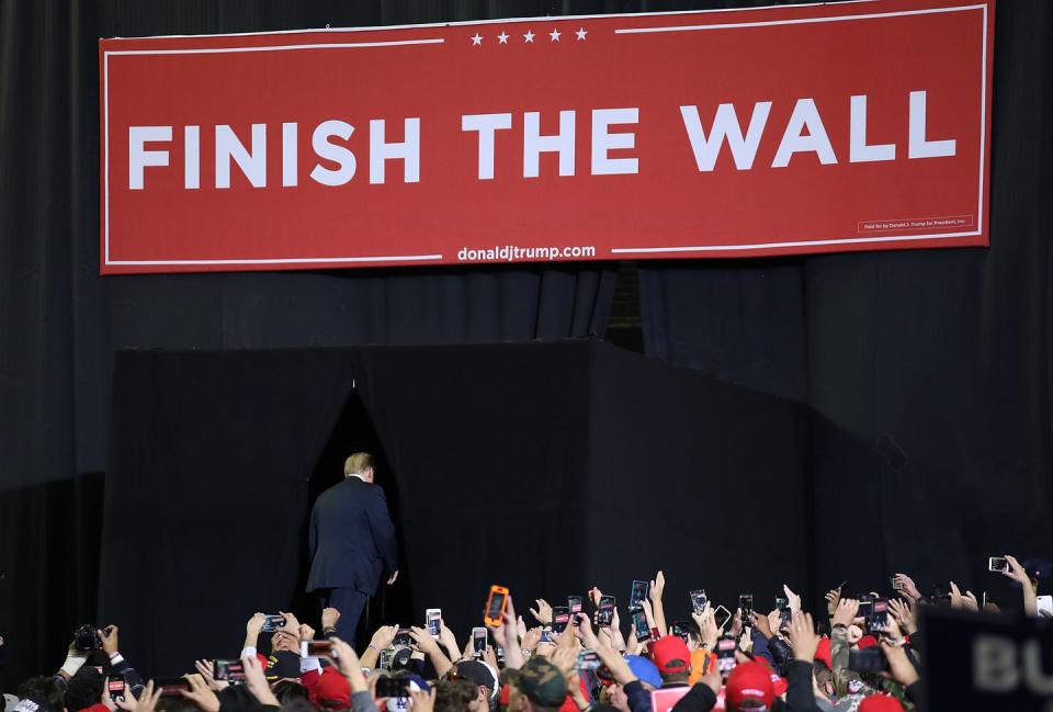 <p>Trump leaves the stage of his rally on Monday. Above him is a sign that says, "Finish The Wall."</p>
