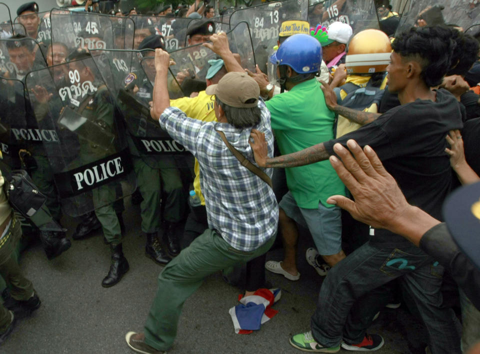 Members of the People's Alliance for Democracy (PAD) demonstrators scuffle with Thai police officers on a street leading to parliament house Friday, June 1, 2012. Thai politics has shifted its focus to the streets again after thousands of protesters have deterred lawmakers from deliberating a bill they claimed could whitewash the wrongdoing of politicians and bring back ousted premier Thaksin Shinawatra. (AP Photo/Apichart Weerawong)