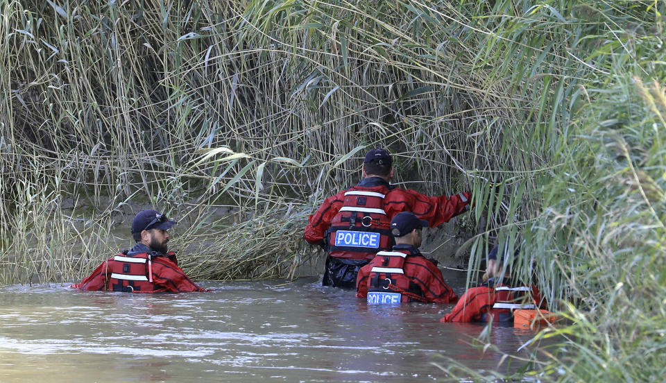 Police officers search the bank of the River Stour during search operations for the missing six-year old boy, Lucas Dobson, who fell into the river Saturday and was swept away while on a fishing trip with family members, in Sandwich, southern England, Monday Aug. 19, 2019. The search for the six-year-old boy resumed Monday, but police have said it is "unlikely" he will be found alive. (Gareth Fuller/PA via AP)