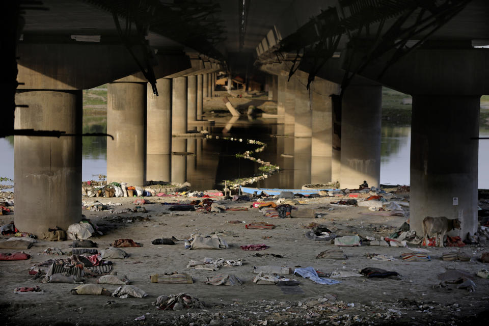 Beddings and other belongings of Indian migrant laborers and homeless people lie scattered after they were evicted from the banks of Yamuna River where they were squatting during lockdown in New Delhi, India, Wednesday, April 15, 2020. Indian Prime Minister Narendra Modi on Tuesday extended the world's largest coronavirus lockdown to head off the epidemic's peak, with officials racing to make up for lost time. (AP Photo/Altaf Qadri)