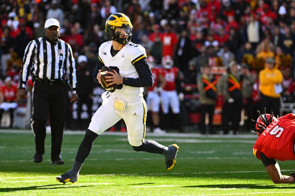 Michigan Wolverines quarterback J.J. McCarthy rolls out against the Maryland Terrapins during the first half at SECU Stadium in College Park, Maryland on Nov. 19, 2023.