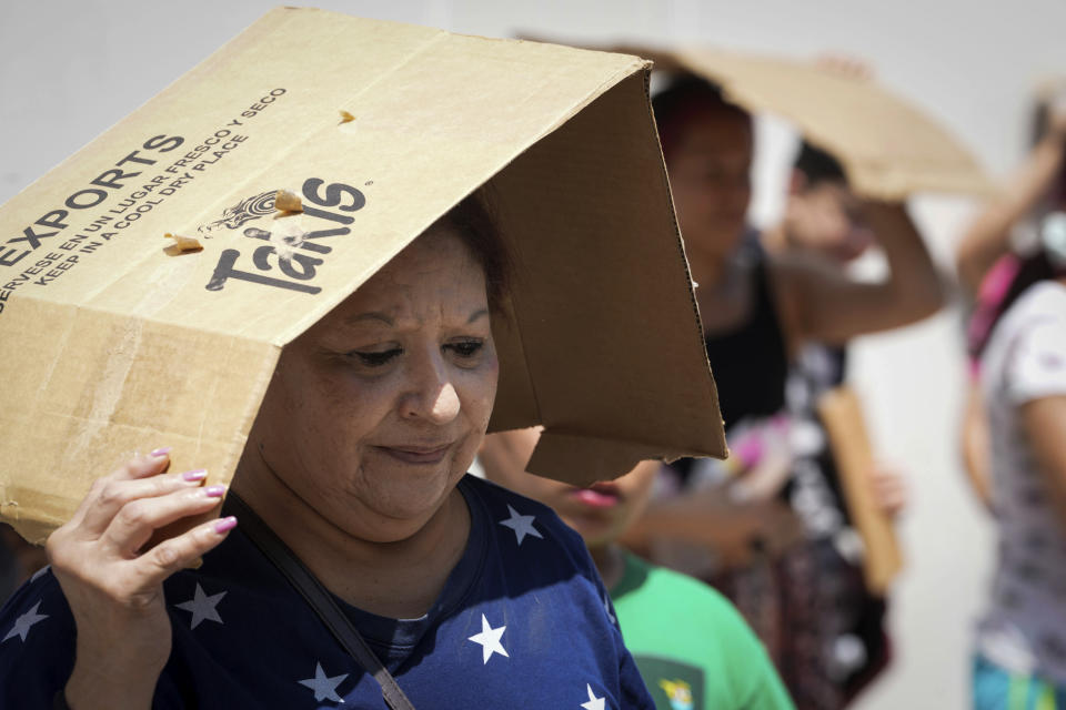 FILE - Margaret Cantu waits in the heat for food and water from volunteers Saturday, May 18, 2024, at Sam Houston Math, Science and Technology Center in Houston. (Jon Shapley/Houston Chronicle via AP)/Houston Chronicle via AP, File)