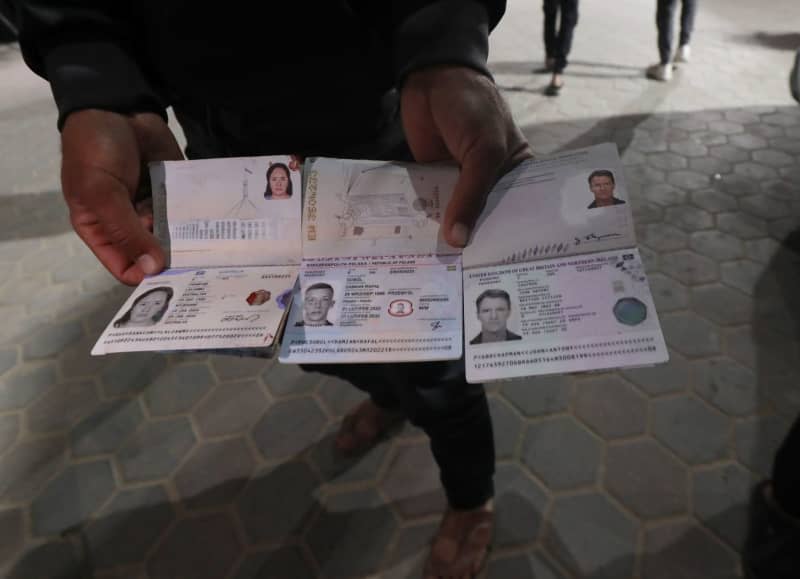 A person holds the passports belonging to deceased officials of the US-based international volunteer aid organization World Central Kitchen (WCK), following an Israeli attack on a WCK vehicle in Deir Al-Balah. Omar Ashtawy/APA Images via ZUMA Press Wire/dpa