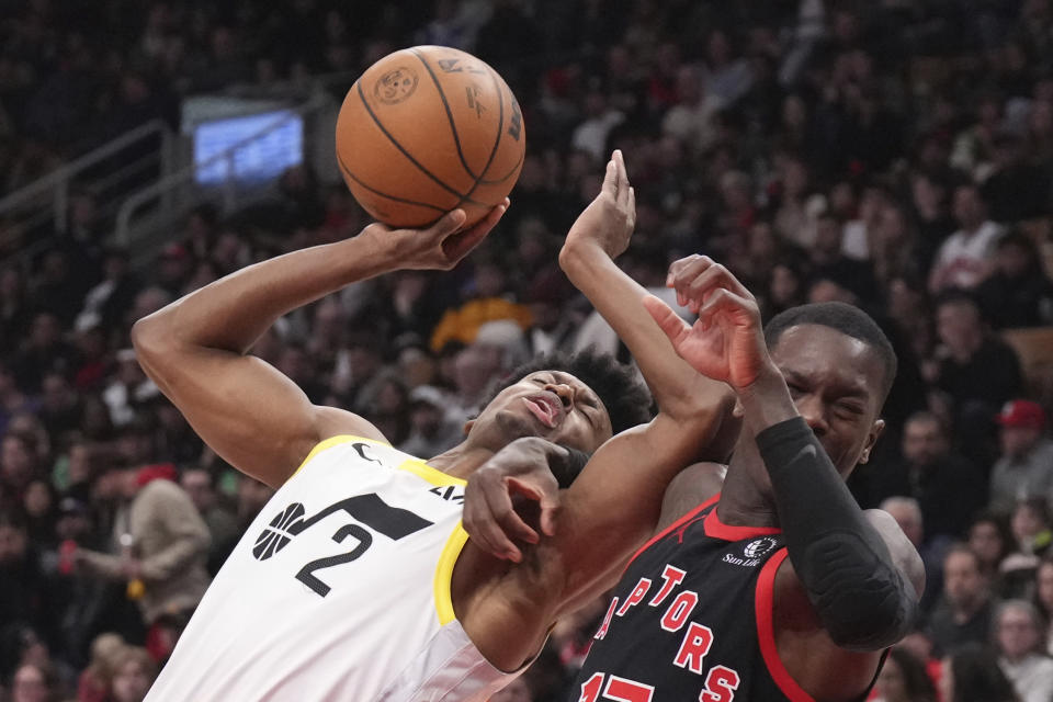 Utah Jazz guard Collin Sexton (2) is fouled by Toronto Raptors guard Dennis Schroder during the first half of an NBA basketball game Saturday, Dec. 23, 2023, in Toronto. (Chris Young/The Canadian Press via AP)