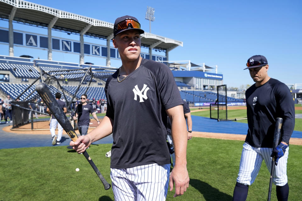 New York Yankees right fielder Aaron Judge, left, and outfielder Giancarlo Stanton walk off the field after batting practice before a spring training baseball game against the Minnesota Twins Monday, Feb. 26, 2024, in Tampa, Fla. (AP Photo/Charlie Neibergall)