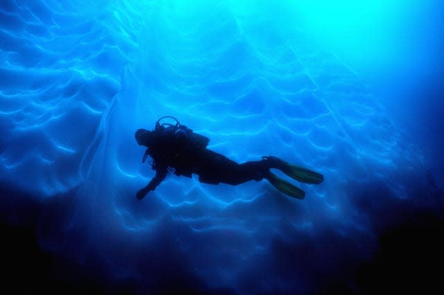 Diver against fluted ice at Antarctic Penninsula