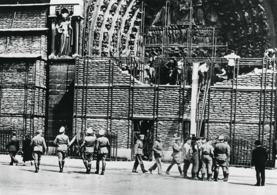 <div class="inline-image__caption"><p>Clearing of sandbag protection from the facade of Notre Dame, German-occupied Paris, 1940. </p></div> <div class="inline-image__credit">Art Media/Print Collector/Getty</div>