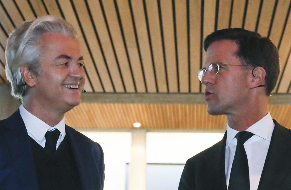 Dutch Prime Minister Mark Rutte, right, and right-wing populist leader Geert Wilders, talk prior to a national televised debate, the first head-to-head meeting of the two political party leaders since the start of the election campaign, at Erasmus University in Rotterdam, Netherlands, Monday, March 13, 2017. (Yves Herman POOL via AP)