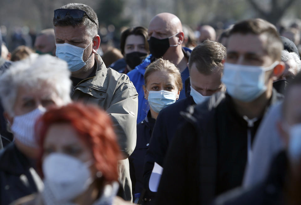 People wait in line to receive a dose of the AstraZeneca vaccine at Belgrade Fair makeshift vaccination center in Belgrade, Serbia, Saturday, March 27, 2021. Thousands of vaccine-seekers from Serbia's neighboring states have flocked to Belgrade after Serbian authorities offered free coronavirus jabs for foreigners if they show up over the weekend. Many arriving with their entire families, long lines of Bosnians, Montenegrins, North Macedonians and even Albanians formed Saturday in front of the main vaccination center in the Serbian capital. (AP Photo/Darko Vojinovic)