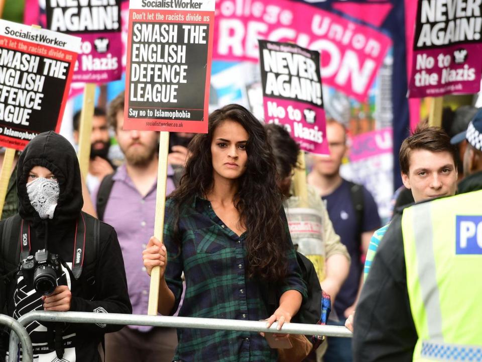 People protest against the English Defence League (EDL) in central London, with one woman holding a Socialist Worker placard reading 'Don't let the fascists divide us, smash the English defence league, say no to Islamophobia (David Mirzoeff/PA)