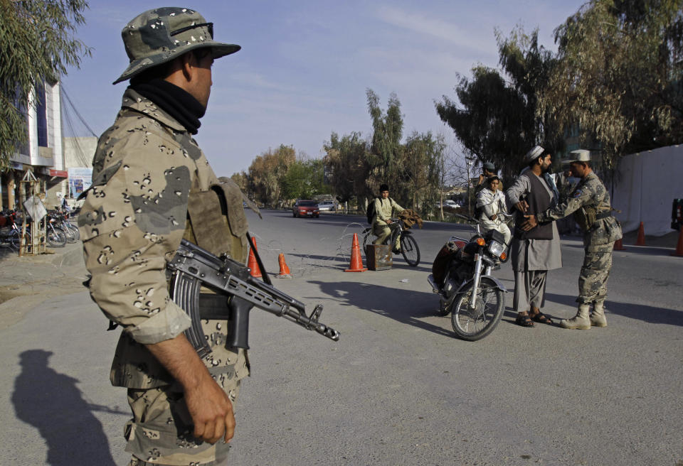 An Afghan security personnel, right, searchs a man on a street in Kandahar, southern Afghanistan, Wednesday, March 26, 2014. Eight Afghan presidential candidates are campaigning in the presidential election scheduled for April 5, 2014. (AP Photo/Allauddin Khan)