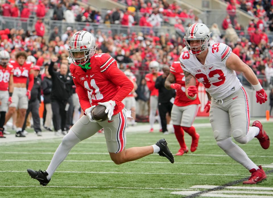 Ohio State Buckeyes wide receiver Jaxon Smith-Njigba (11) runs past defensive end Jack Sawyer (33) during the spring football game at Ohio Stadium in Columbus on April 16, 2022.