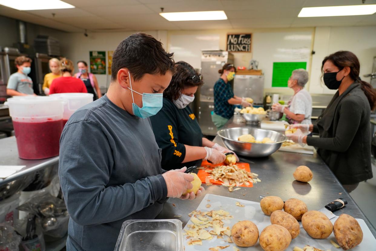 Volunteers peel potatoes and prepare other Thanksgiving food for seniors in Hawthorne, N.J., on Nov. 3, 2020. With a fall surge of coronavirus infections gripping the U.S., many Americans are forgoing tradition and getting creative with celebrations.