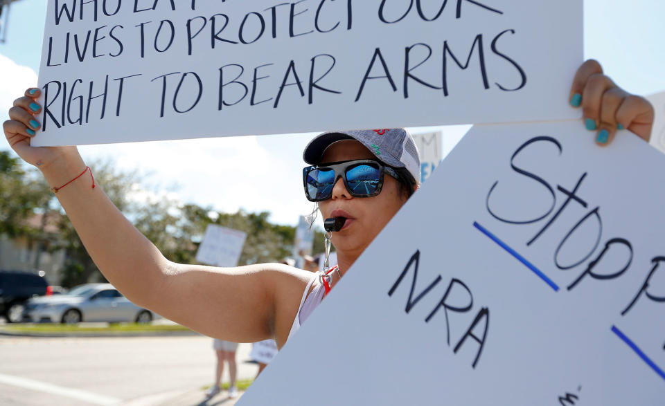 <p>Juliana Cruz, of Parkland, Fla., stands on a street corner holding up an anti gun sign in Parkland, Fla., on Saturday, Feb. 17, 2018. (Photo: Brynn Anderson/AP) </p>