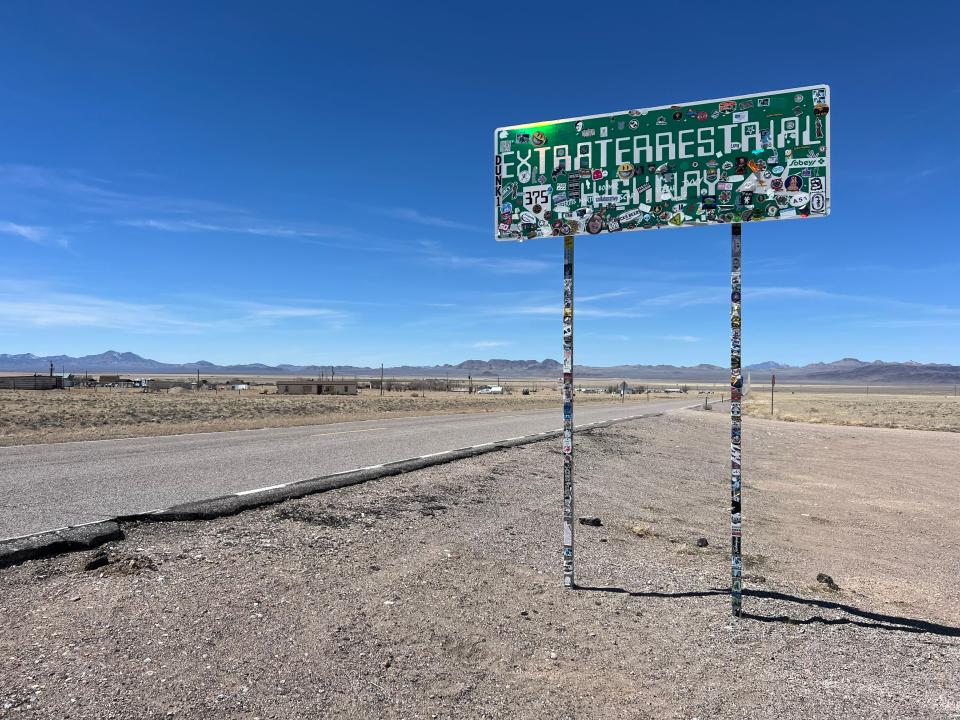 A green sign covered in stickers that reads "Extraterrestrial Highway."