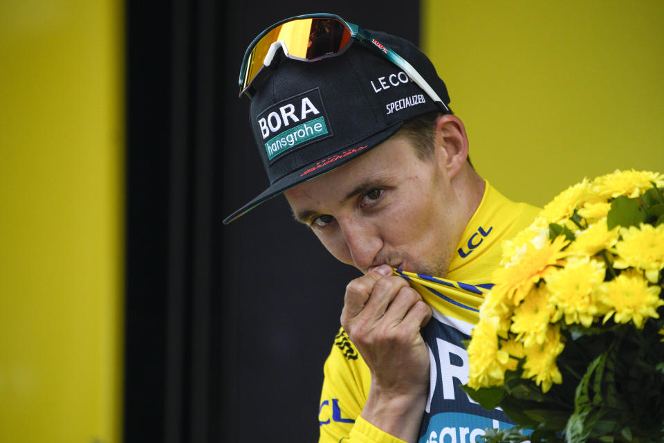 Stage winner Australia's Jai Hindley kisses the overall leader's yellow jersey on the podium after the fifth stage of the Tour de France cycling race over 163 kilometers (101 miles) with start in Pau and finish in Laruns, France, Wednesday, July 5, 2023 (AP Photo/Daniel Cole)