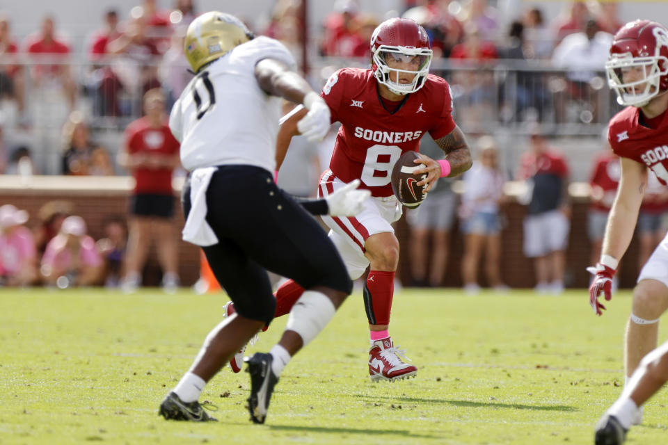 Oklahoma quarterback Dillon Gabriel (8) carries the ball as UCF linebacker Jason Johnson (0) defends in the first half of an NCAA college football game, Saturday, Oct. 21, 2023, in Norman, Okla. (AP Photo/Nate Billings)