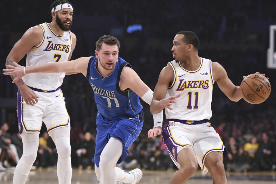 Dallas Mavericks guard Luka Doncic (77) defends Los Angeles Lakers guard Avery Bradley (11) during the first half of an NBA basketball game Sunday, Dec. 29, 2019, in Los Angeles. (AP Photo/Michael Owen Baker)