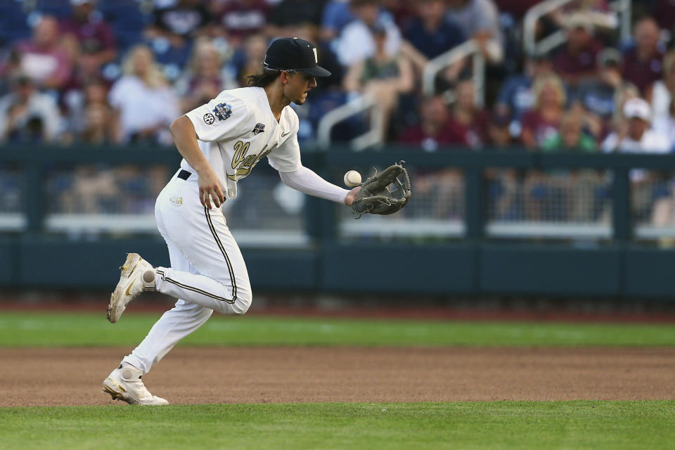 Vanderbilt infielder Carter Young (9) bobbles a ball from Mississippi State outfielder Rowdey Jordan during the fifth inning in Game 3 of the NCAA College World Series baseball finals, Wednesday, June 30, 2021, in Omaha, Neb. (AP Photo/John Peterson)