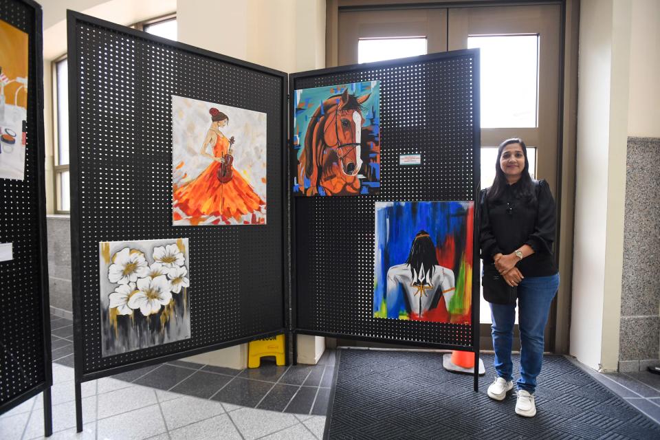 Artist Jagruti Mehta poses alongside her artwork during the AAPI Heritage Month celebration inside Jackson City Hall on Friday, May 3, 2024.