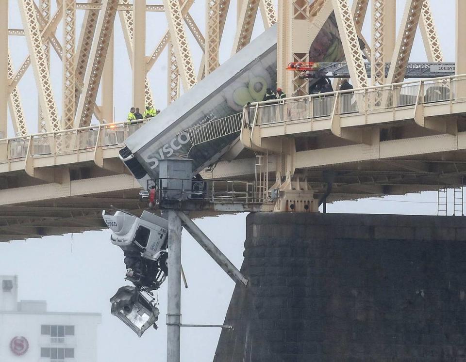 A semi-truck dangles over the southbound lane of the Second Street Bridge in Louisville Friday afternoon. One person was rescued from the vehicle.