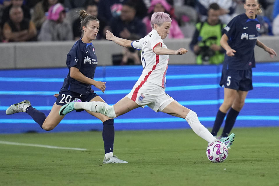 OL Reign forward Megan Rapinoe, center, passes the ball as San Diego Wave defender Christen Westphal defends during the second half of an NWSL semifinal playoff soccer match Sunday, Nov. 5, 2023, in San Diego. (AP Photo/Gregory Bull)