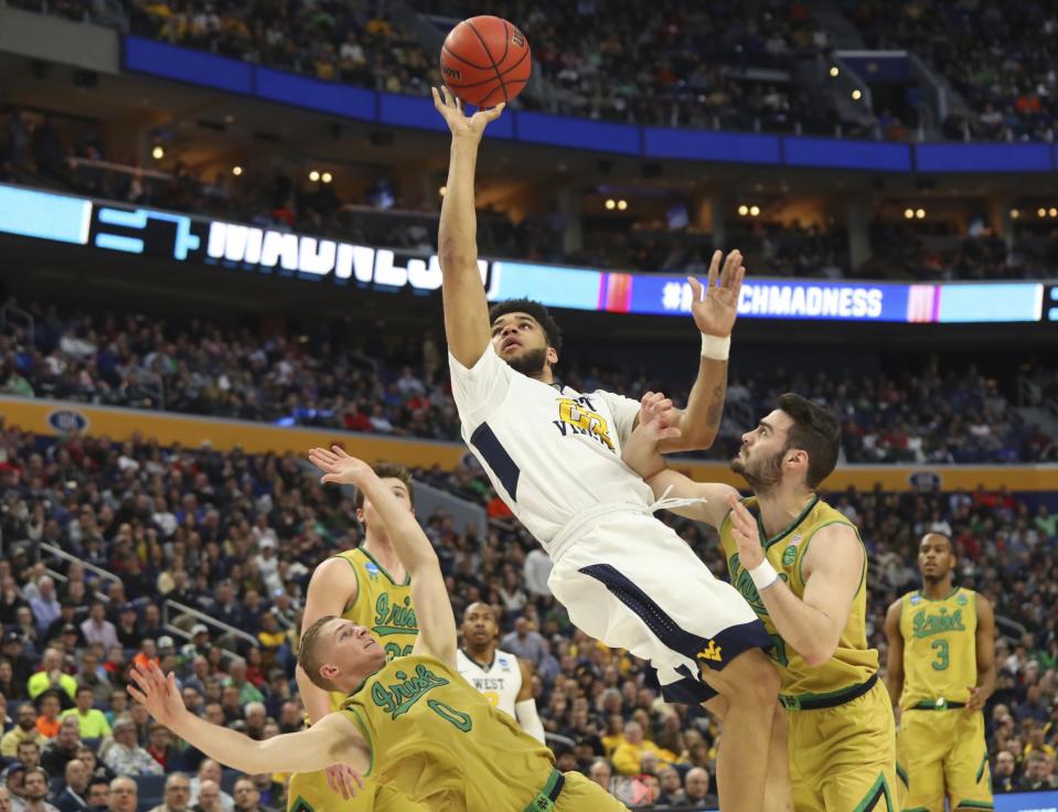 <p>West Virginia forward Esa Ahmad (23) goes to the basket against Notre Dame guard Rex Pflueger (0) and guard Matt Farrell (5) during the first half of a second-round men’s college basketball game in the NCAA Tournament, Saturday, March 18, 2017, in Buffalo, N.Y. (AP Photo/Bill Wippert) </p>