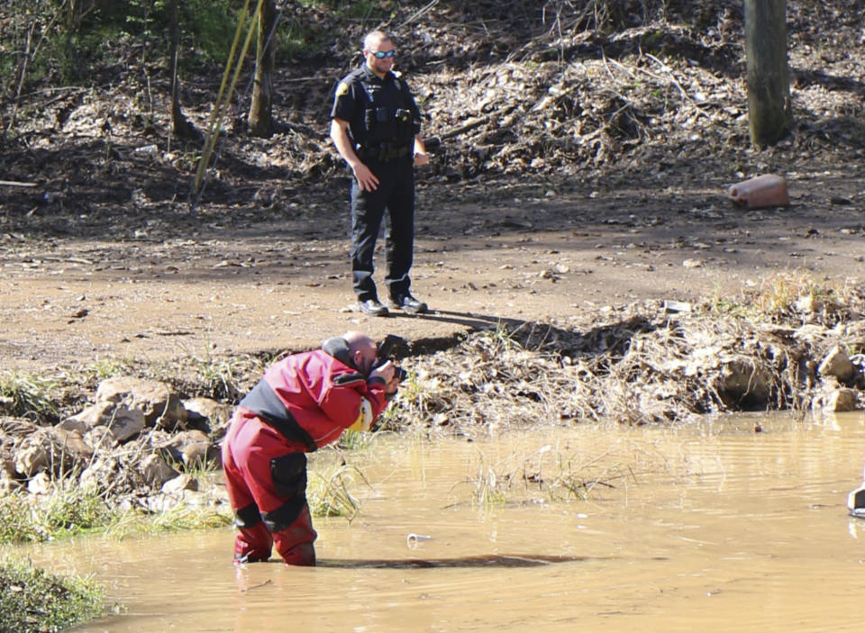 In this image provided by the Tuscaloosa (Ala.) Police Department, officers work at at the scene where three bodies were found in receding floodwaters on March 24, 2022, in the Holt community, a rural area a few miles east of Tuscaloosa, Ala.(AP Photo/Tuscaloosa Police Department)