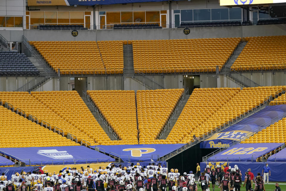 The Pittsburgh football team looks toward the empty bleachers after defeating Austin Peay in an NCAA college football game, Saturday, Sept. 12, 2020, in Pittsburgh. In a quirk this season, No. 5 Notre Dame enjoys a greater home-field advantage than most of its opponents: As of now, the Fighting Irish are slated to play in front of only one crowd bigger than their own, which is limited to about 10,000 people because of the pandemic. Pitt, Boston College, North Carolina and Wake Forest have not allowed any spectators to attend so far. (AP Photo/Keith Srakocic)