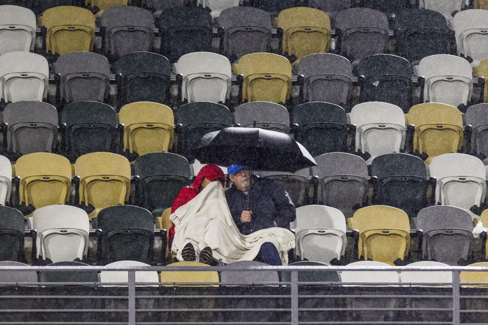 Fans brave the cold weather and rain during the Belinda Bencic, of Switzerland, and Jessica Pegula semifinal action at the Charleston Open tennis tournament in Charleston, S.C., Saturday, April 8, 2023. The match was suspended until Sunday. (AP Photo/Mic Smith)