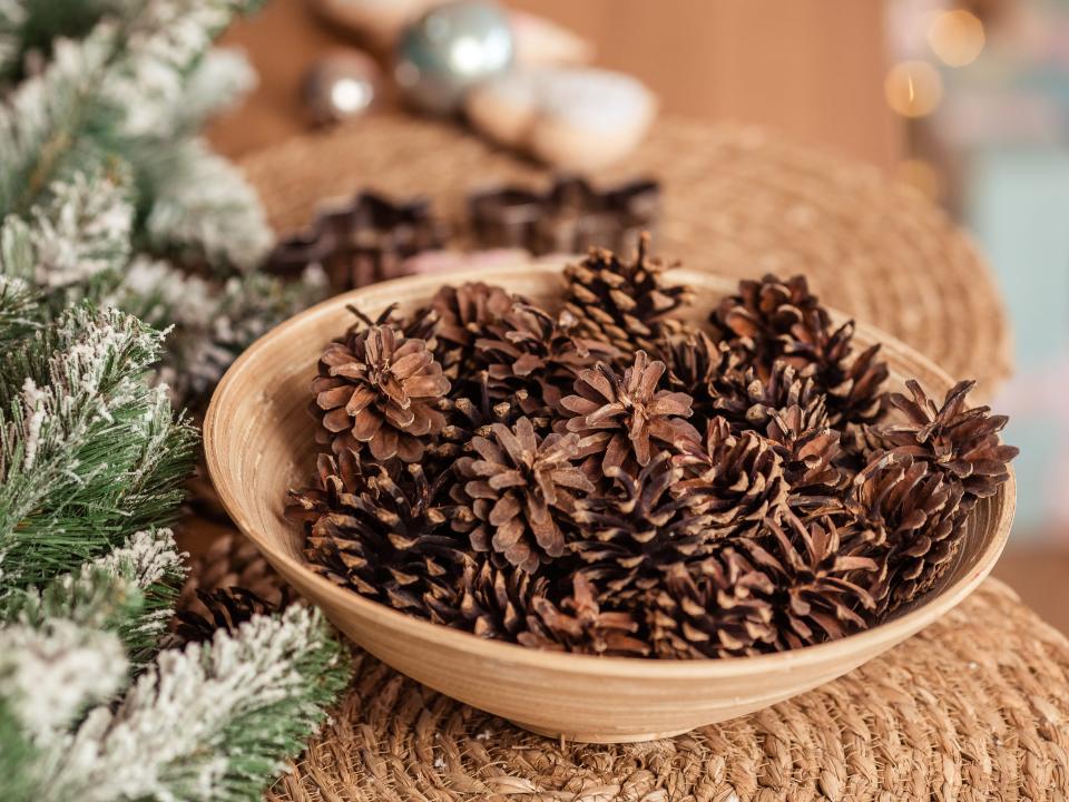 Basket with pine cones close-up on a festive table, with place for text.