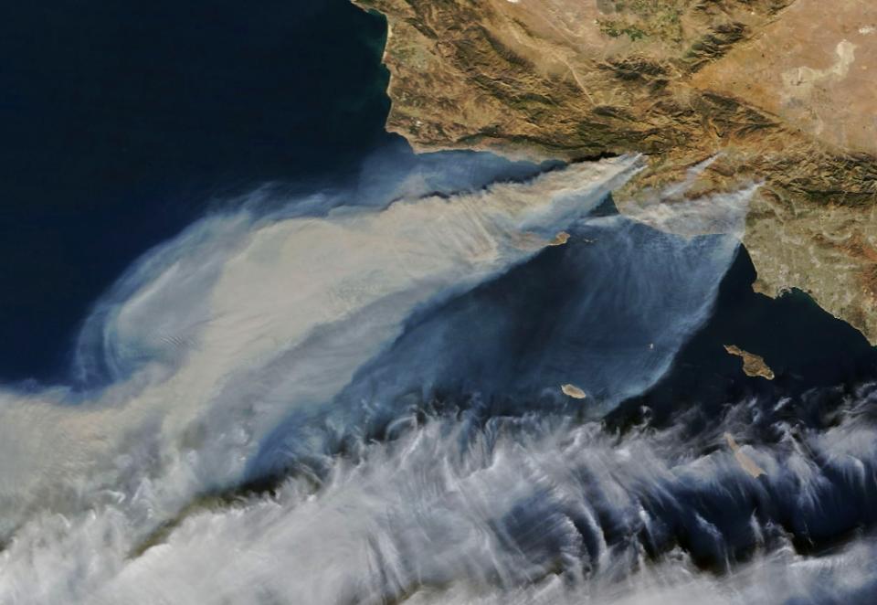 <p>Thick smoke streams from several fires in southern California on Dec. 5, 2017. The largest of the blazes – the fast-moving Thomas fire in Ventura County – had charred more than 65,000 acres, according to Cal Fire. Smaller smoke plumes from the Creek and Rye fires are also visible. (Photo: NASA/AFP) </p>