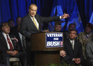 FILE - Former U.S. Sen. Bob Dole, surrounded by military veterans, gestures during a Bush-Cheney 2004 National Veterans Leadership Team rally Tuesday afternoon May 11, 2004, in Tampa, Fla. Bob Dole, who overcame disabling war wounds to become a sharp-tongued Senate leader from Kansas, a Republican presidential candidate and then a symbol and celebrant of his dwindling generation of World War II veterans, has died. He was 98. His wife, Elizabeth Dole, posted the announcement Sunday, Dec. 5, 2021, on Twitter. (AP Photo/Chris O'Meara, File)