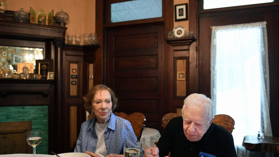 rosalynn and jimmy carter sit at a dining table and eat a meal together