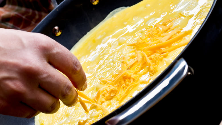 Adding cheese to omelet base