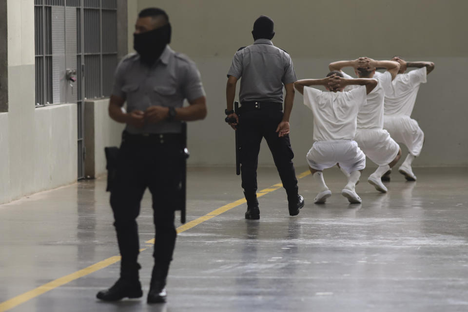 Presos hacen ejercicios bajo la vigilancia de guardias de prisión durante una visita de prensa en el Centro de Confinamiento del Terrorismo, una mega prisión en Tecololuca, El Salvador, el jueves 12 de octubre de 2023. (AP Foto/Salvador Meléndez)