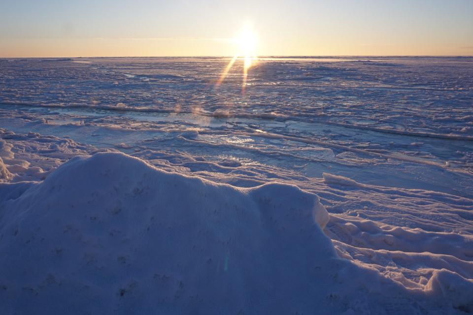 The rising sun lights up the newly frozen Norton Sound sea ice off Nome on winter solstice, Dec. 21, 2018. (Photo by Yereth Rosen/Alaska Beacon)