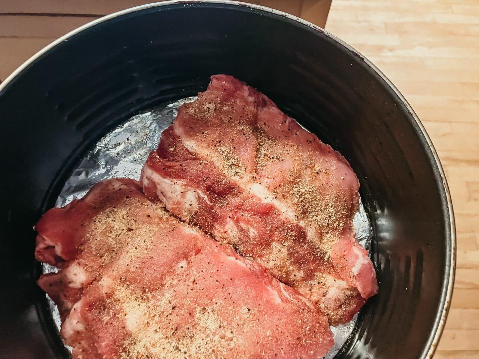 two seasoned half racks of ribs in an air fryer