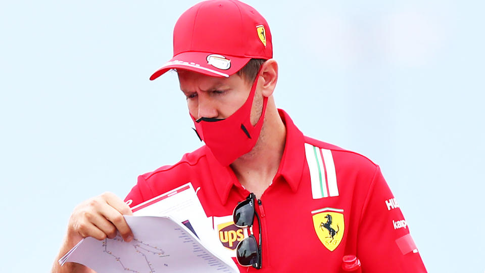 Ferrari driver Sebastian Vettel is pictured looking at notes ahead of the Hungarian Grand Prix.