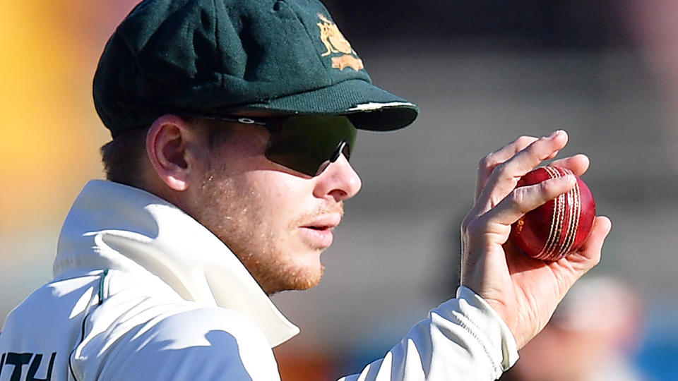 Pictured here, Aussie cricket star Steve Smith holding a ball in his hand.