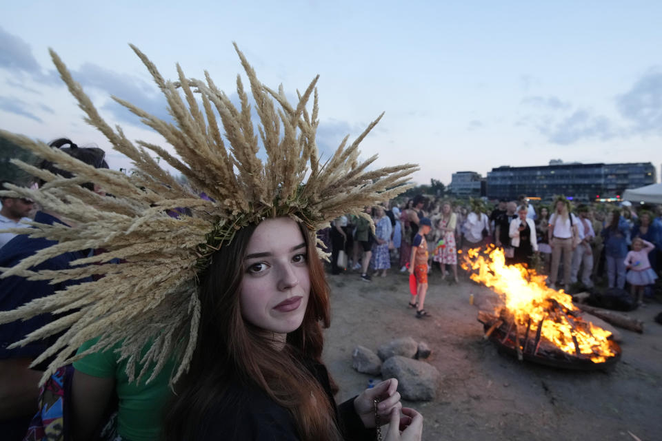 A young Ukrainian woman wears an ear of grain braid during a traditional Ukrainian celebration of Kupalo Night, in Warsaw, Poland, on Saturday, June 22, 2024. Ukrainians in Warsaw jumped over a bonfire and floated braids to honor the vital powers of water and fire on the Vistula River bank Saturday night, as they celebrated their solstice tradition of Ivan Kupalo Night away from war-torn home. (AP Photo/Czarek Sokolowski)