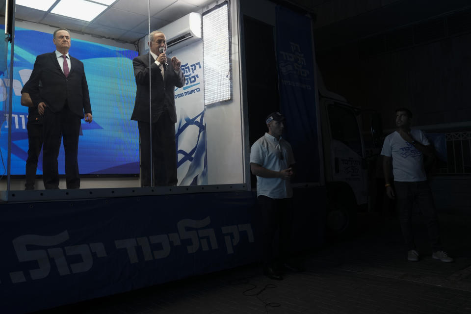 Former Israeli Prime Minister Benjamin Netanyahu delivers an election campaign speech from inside a modified delivery truck with a side wall replaced with bulletproof glass, in Beersheba, southern Israel, Tuesday, Sept. 13, 2022. As he hits the campaign trail for the fifth time in less than four years, Netanyahu is addressing supporters from the strange new vehicle dubbed the “Bibibus" after his popular nickname. (AP Photo/Ariel Schalit)