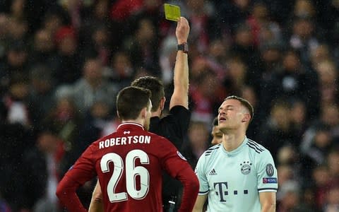 Bayern Munich's German midfielder Joshua Kimmich (R) receives a yellow card from Italian referee Gianluca Rocchi during the UEFA Champions League round of 16, first leg football match between Liverpool and Bayern Munich - Credit: Getty images