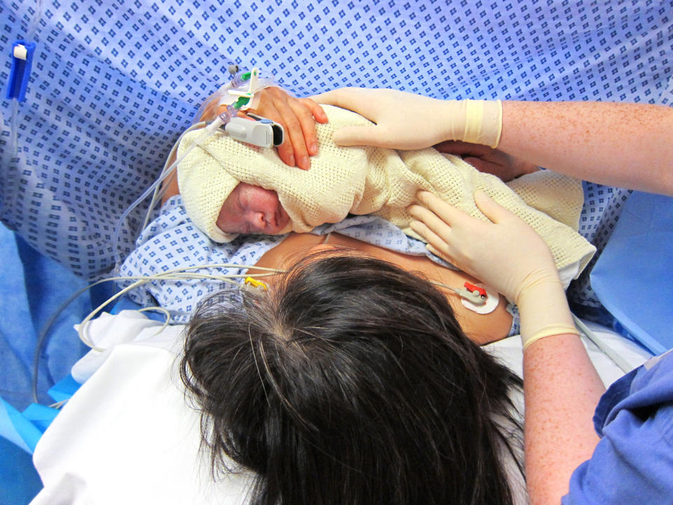 A woman holds her newborn baby.